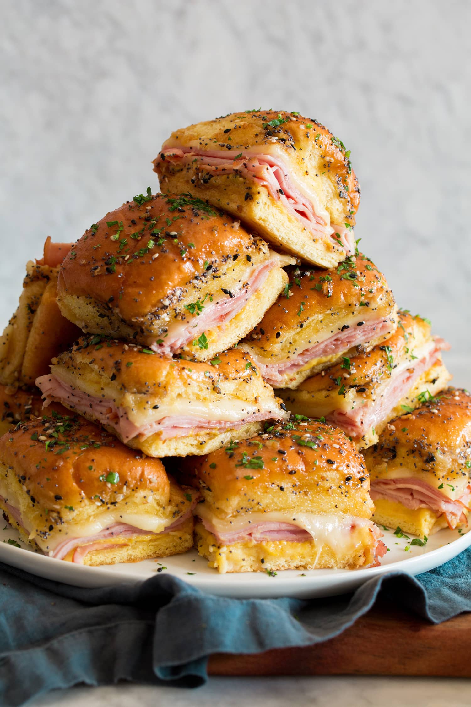 Stack of ham and cheese sliders in a pyramid shape.
